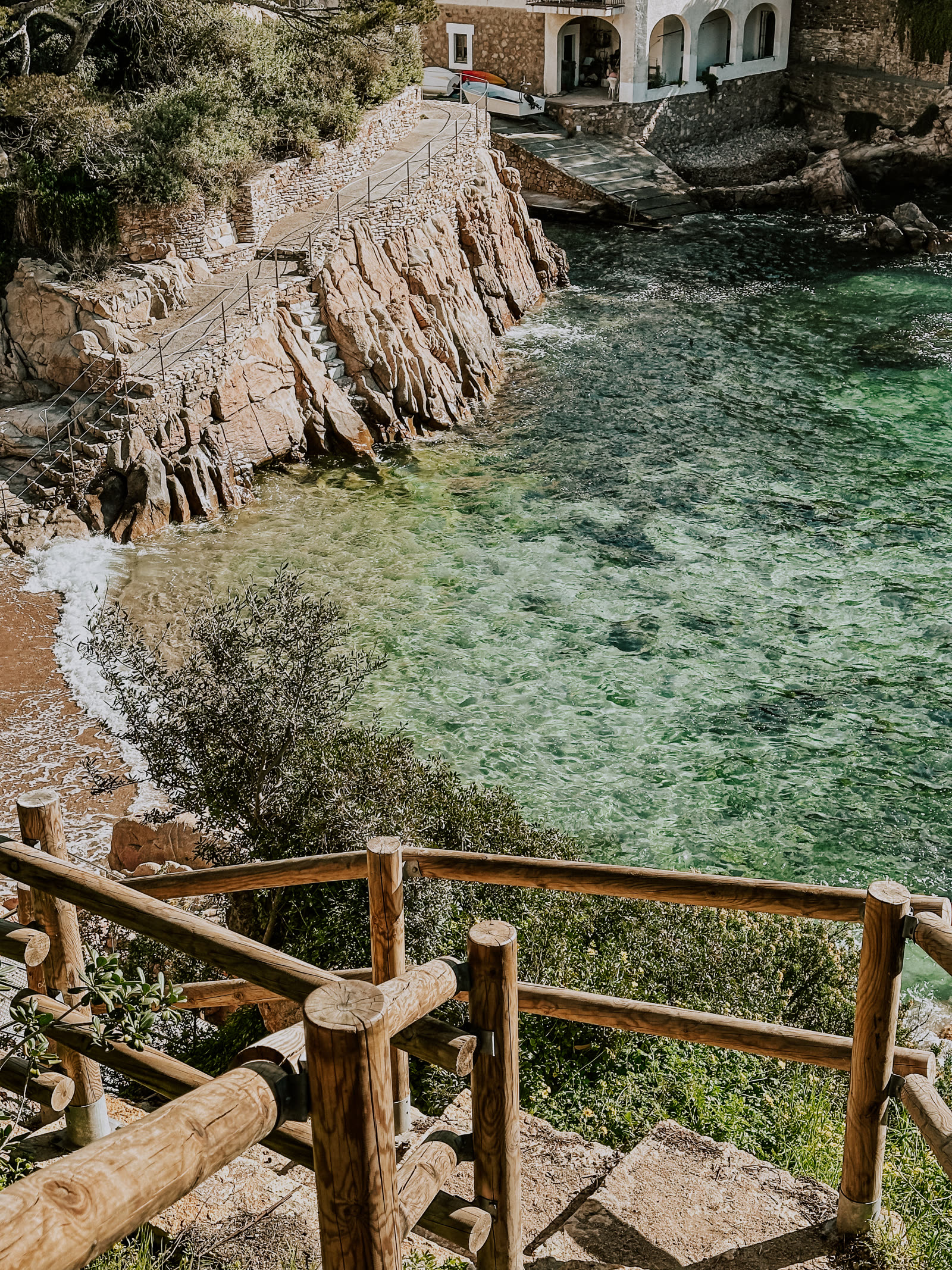 Stone steps of the Camí de Ronda winding down to clear turquoise water on the Costa Brava